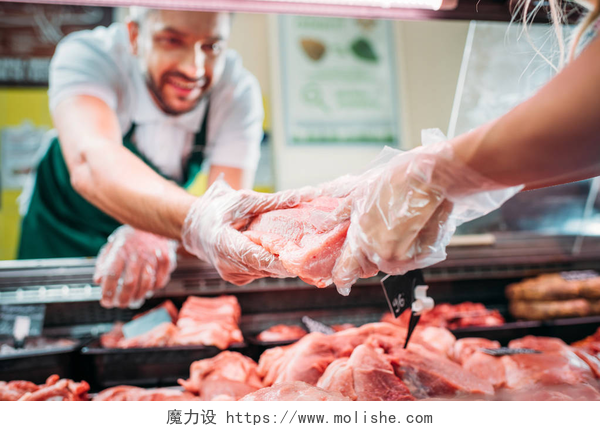 卖猪肉的老板给顾客挑选猪肉局部特写商店售货员与生肉